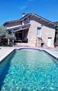 - une piscine en face d'une maison dans l'établissement LES CHAISES LONGUES, à Peyrins