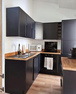 uma cozinha com armários pretos e um lavatório em L appartement de Manon, centre historique du vieil Antibes em Antibes