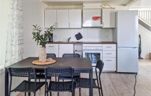 een keuken met een tafel en stoelen en een koelkast bij Nice Home In Risr With Kitchen in Risør