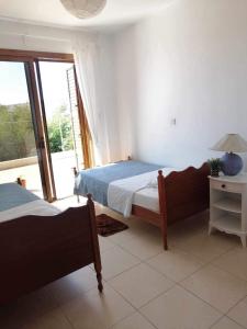 1 dormitorio con 2 camas y ventana en Stavros Agios Dimitrianos Village House, en Ayios Dhimitrianos