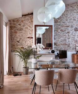 een woonkamer met een tafel en stoelen en een spiegel bij L appartement de Manon, centre historique du vieil Antibes in Antibes