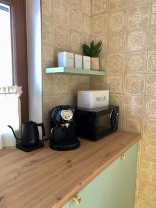 a counter with a microwave on top of a table at RELAS - przytulny domek z dwoma sypialniami i antresolą oraz JACUZZI in Murzasichle
