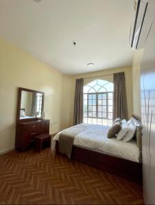 a bedroom with a bed and a large window at Deluxe Apartment in Muscat