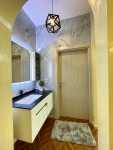 Deluxe Apartment في مسقط: حمام مع حوض ومرآة
