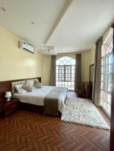 Deluxe Apartment في مسقط: غرفة نوم بسرير ونافذة كبيرة