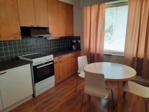 a kitchen with a table and a table and a table and chairs at Family House Kupittaa Diplomat, Sauna, Garden, whole house for you in Turku