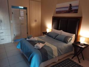 a bedroom with a large bed with two pillows on it at Desert Pearl Self catering & Accommodation in Walvis Bay