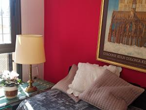 1 dormitorio con paredes rojas y 1 cama con lámpara en Lara en Mendoza