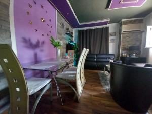 a dining room with a table and chairs and purple ceilings at S Type Apartment in Split