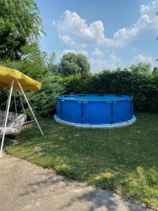 uma banheira azul sentada na relva ao lado de uma tenda em Danube River house em Novi Sad