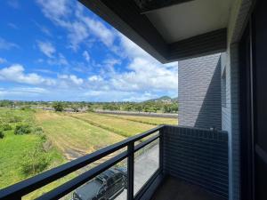 einen Balkon mit Blick auf ein Auto auf einem Feld in der Unterkunft 壹玖住宿 in Suao