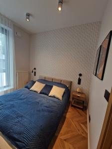 Schlafzimmer mit einem Bett mit blauer Decke in der Unterkunft Apartament Platinum z tarasem 70 m2, 50 m od Placu Litewskiego in Lublin