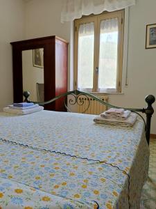 a bedroom with a bed with a blue and yellow blanket at Casa Le Piane in Strettura