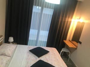 a bedroom with a bed with a table and a window at Tanem Suit in Kemer +48 photos