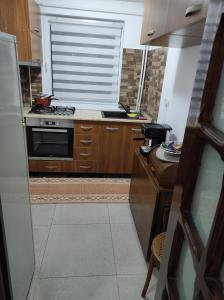 a kitchen with wooden cabinets and a stove top oven at Apartament 2 camere tip studio in Râmnicu Vâlcea