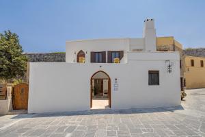 a white house with a door in a courtyard at Nikolas Old Town in Rhodes Town +13 photos