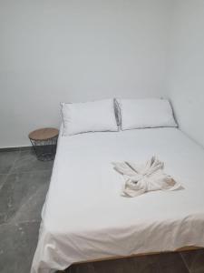 Una cama blanca con dos almohadas y un arco. en מג׳יק פלייס, en Eilat