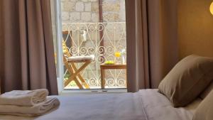 ein Schlafzimmer mit Bett und Blick auf einen Balkon in der Unterkunft Mascheroni Luxury Rooms in Dubrovnik