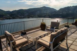 einen Balkon mit 2 Stühlen und einem Tisch sowie Blick auf das Wasser in der Unterkunft Como Unbelievable View - The House Of Travelers in Como