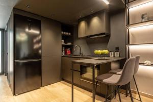 a kitchen with a table and two chairs and a refrigerator at Loft M8 in Alexandroupoli