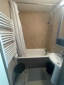 a bathroom with a bath tub and a sink at Samoëns 1600 studio au pied des pistes in Samoëns