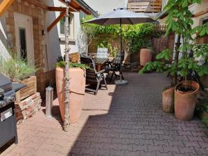 un patio con sombrilla, mesa y sillas en Haus Zwanzig, en Weisel