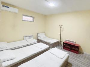 a room with three beds in it with a window at Stay hostel in Tashkent