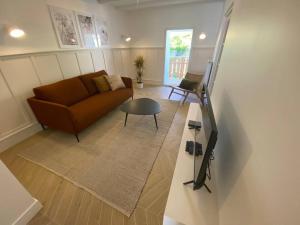 ein Wohnzimmer mit einem Sofa und einem Tisch in der Unterkunft Lac's Lodge ¤ Maison coquette à 10min du lac in Annecy