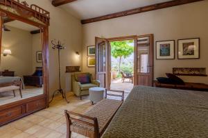 a bedroom with a bed and a living room at Baglio Giammaccaro in Castelluzzo