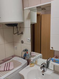 a bathroom with a sink and a toilet and a mirror at Central apartment in Gevgelija