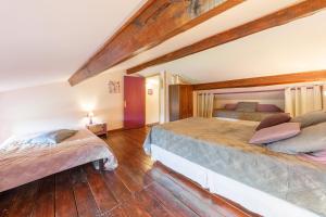 two beds in a bedroom with wooden floors at LE CLOS DU MOUY in La Souche