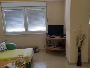 a room with a bed and a desk with a television at Central apartment in Gevgelija