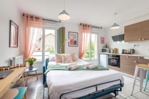 een slaapkamer met een groot bed en een keuken bij Studio entre Disney, Paris et Aéroport Charles de Gaulle - Parking souterrain gratuit in Brou-sur-Chantereine