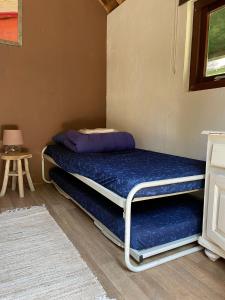 een kleine kamer met een bed met een kussen erop bij Basic Lodge in Nature in Schagerbrug
