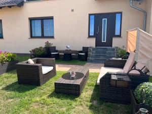 a patio with wicker chairs and tables in the grass at Ferienwohnung PuraVida Ostsee 5A in Kühlungsborn