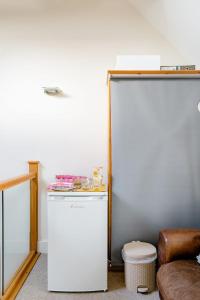 frigorifero bianco in camera con sgabello di Roselands 