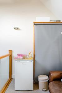 a white refrigerator in a room with a stool at Roselands 