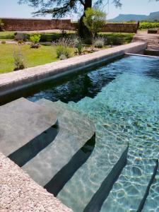una piscina de agua azul en un patio en A l Aube du Midi, en Bagnols-sur-Cèze