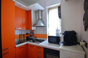 een keuken met oranje kasten, een fornuis en een raam bij PollyHouse - Apartment in Turijn