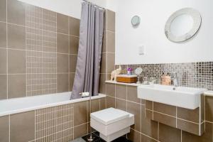 bagno con lavandino, servizi igienici e specchio di Roselands 
