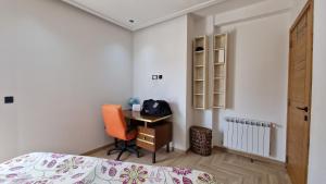sypialnia z biurkiem, łóżkiem i krzesłem w obiekcie Lovely apartment in Monastir w mieście Monastir