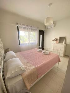 a bedroom with a large bed with a pink blanket at Magio House in Ixia