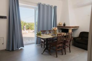 a dining room with a table and chairs and a window at Villa Comes in Monopoli