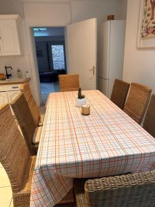 une cuisine avec une table, des chaises et un tissu de table dans l'établissement Agréable maison très cosy centre Boulogne s/mer, à Boulogne-sur-Mer