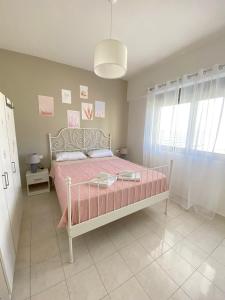 a bedroom with a pink bed with a pink blanket at Magio House in Ixia