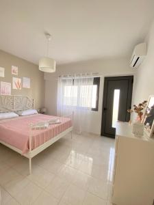 sypialnia z różowym łóżkiem w pokoju w obiekcie Magio House w miejscowości Ixiá