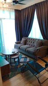 uma sala de estar com um sofá e uma mesa em Muslim Homestay at Meru Ipoh With Swimming Pool & Free Parkings em Ipoh