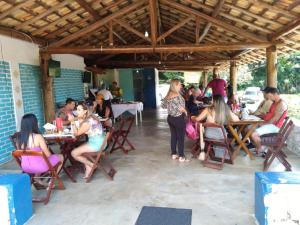un gruppo di persone seduti ai tavoli in un ristorante di PousadaTopFest a Poços de Caldas
