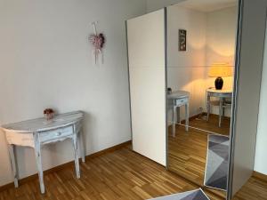 Cette chambre comprend un miroir, une table et une lampe. dans l'établissement Oasi 2, à Kreuzlingen