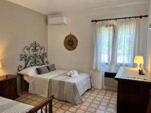 a bedroom with two beds and a clock on the wall at Villa Domus de Janna in Olbia